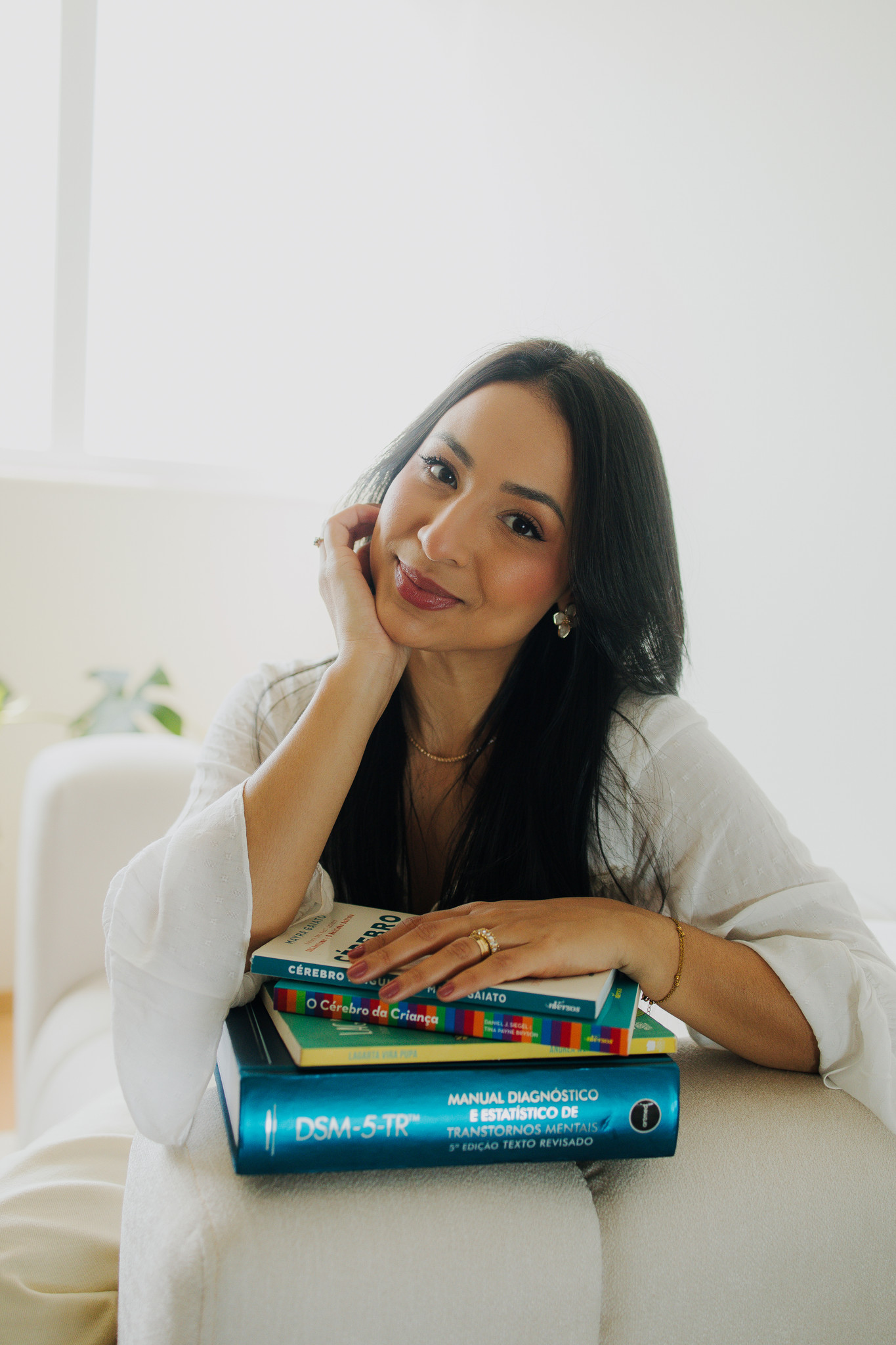 Psicóloga Jarliny Souza apoiada em livros de psicologia